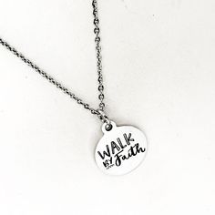 This silver necklace is a simple but beautiful gift for a loved one in your life. It is a stainless steel laser engraved charm on a stainless steel link chain. The charm has the following on it: Walk by Faith This necklace is available on a chain in your choice of 16, 18, 20, 22, 24, 26, 28 or 30 iInches. The pendant is also available for separate purchase if you have another necklace on which you would like to wear it. Each item comes individually boxed and ready to give as a gift. This jewelry Silver Hand Stamped Meaningful Charm Necklace, Inspirational Nickel-free Silver Necklace, Everyday Adjustable Stainless Steel Charm Necklace, Inspirational Silver Charm Necklace For Personalized Gifts, Inspirational Nickel-free Silver Charm Necklaces, Inspirational Silver Nickel-free Charm Necklaces, Everyday Hand Stamped Stainless Steel Jewelry, Everyday Stainless Steel Charm Necklace With Round Pendant, Hypoallergenic Stainless Steel Necklace For Personalized Gifts