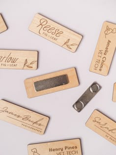 wooden name tags with metal clip on white surface, surrounded by other wood labels and magnets