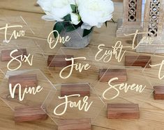 there are some wooden blocks on the table with white flowers in it and one is for each name