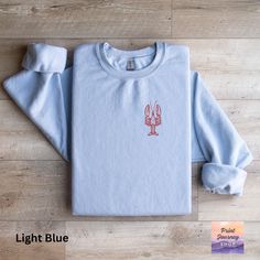 🦞 Embrace coastal vibes with this unique lobster graphic sweatshirt! Perfect for ocean lovers, this nautical-themed top adds a touch of sea life to your casual style. 🏖️ Comfortable and stylish for everyday wear, it's the ideal addition to your coastal clothing collection. Dive into fashion with this cozy and trendy sweatshirt today! 🌊  Gildan 18000 Sweatshirt: A sturdy and warm sweatshirt bound to keep you warm in the colder months. A pre-shrunk, classic fit sweater that's made with air-jet Nautical Cotton Tops For Fall, Lobster Graphic, Coastal Clothing, Lover Clothes, Design Sweatshirt, Coastal Vibes, Ocean Lover, Coastal Style, Fitted Sweater