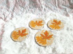 three plates with leaves painted on them are sitting on a white furnishing area