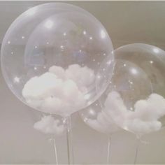 three clear balloons with white clouds on them