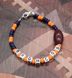 Denver Broncos, Broncos Bracelet, Football Bracelet, Beaded Bracelet, Sports Bracelet Show off your favorite team with one of these bracelets. Broncos made with blue and orange seeds beads, white plastic letters, beading wire, 1 football ball bead, and a lobster clasp. There are so many Varieties out there so if you need something special let me know. Thanks for your business! Please don't forget to like my shop. Sports Bracelets Diy, Broncos Bracelet, Craft Therapy, Team Bracelets, Football Bracelet, Clay Bracelets, Plastic Letters, Clay Bead Bracelet, Bracelets Handmade Diy