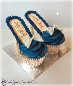 two cupcakes with blue frosting and bows on them