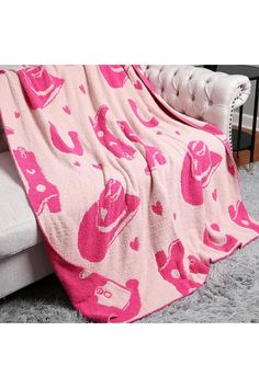 a pink teddy bear blanket on top of a couch