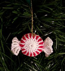 a red and white ornament hanging from a christmas tree