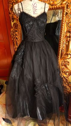 "This gorgeous formal gown is from the 50s by Emma Domb.  Rare solid black.  The underdress is made up of a black shiny acetate. There are two layers of tulle.  The under layer is a coarse tulle to give it its shape.  The outer layer is a finer tulle.  On the bodice and on the skirt are large lace bow appliques. The bodice is boned for structure. Side metal zipper.  There is one repair on the satin underdress near the hem where it looks like the original owners high heel might have gone through. You can't see this  when wearing the dress.  The hem of the tulle in some places has been trimmed (shown) This also does not show because of the fullness and the double layer of tulle.  This is a gorgeous gown and perfect for any formal event or Prom.  It was photographed with an extra petitcoat (n Tulle Ball Gown For Evening, Evening Tulle Ball Gown, Black Organza Ball Gown, Black Organza Ball Gown Dress, Black Organza Evening Gown, Vintage Black Gown For Wedding, Vintage Black Wedding Gown, Black Organza Evening Dress For Prom, Black Tulle Skirt Evening Dress For Formal Occasions