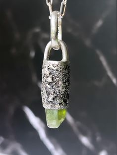 PERIDOT 'EROSION' AMULET NECKLACE. ONE OF A KIND. COLOR: PERIDOT CRYSTAL + TEXTURED, OXIDIZED S.SILVER  PENDANT [WxH]: 0.487"x1.13" bail not included [12.39mm x 28.83mm] VISIBLE CRYSTAL: 0.40" [10.36 mm] 2.7 Oval Cable Chain. [SOLD WITH OR WITHOUT CHAIN] Closure: Lobster claw. WEIGHT: 10.10 grams. [w/o chain] PURITY: .925 HANDMADE. BEFORE ORDERING, PLEASE READ THE DESCRIPTION CAREFULLY, ANY ADDITIONAL INFO CAN BE OBTAINED BY ETSY MESSAGE OR DM ME ON INSTAGRAM @furia_metalsmith. Handmade Peridot Pendant Jewelry, Fusion Peridot Jewelry Gift, Fusion Style Peridot Jewelry As A Gift, Fusion Style Peridot Jewelry Gift, Handmade Silver Peridot Necklace, Handmade Silver Peridot Necklaces, Handmade Silver Necklace With Peridot, Spiritual Silver Tourmaline Jewelry, Spiritual Tourmaline Silver Jewelry