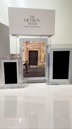 three glass frames sitting next to each other on a white counter top in front of a sign that says the motion frame