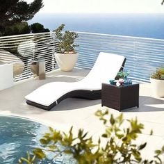 an outdoor lounge chair next to a swimming pool