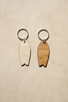 two wooden key chains sitting on top of a table