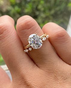 a woman's hand with a ring on it that has a diamond in the middle