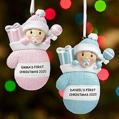 two baby's first christmas ornament hanging from a tree