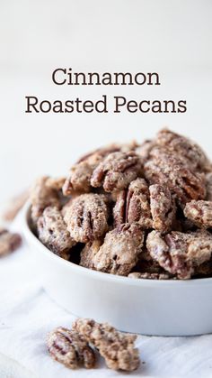 cinnamon roasted pecans in a white bowl on top of a napkin with the words, cinnamon roasted pecans