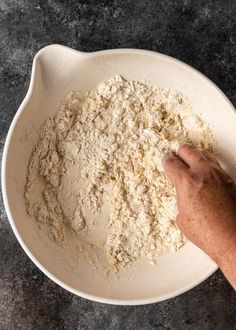 a person mixing flour in a white bowl