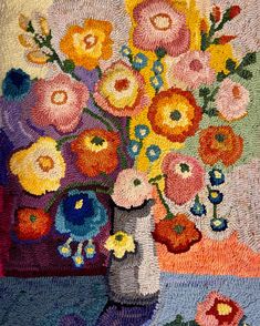 a vase filled with colorful flowers on top of a rug