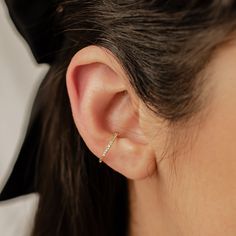 This ear cuff is made from 18 karat gold-plated sterling silver and consists of a single band with squared edges, half covered with tiny white zircon stones embellishing the outer surface. It has a small gap in the band where it fits onto the ear, and two metallic balls on either side of the gap to hold it securely in place. Simple yet sophisticated, this is a versatile piece that will add the perfect amount of extra sparkle to an outfit.  DETAILS: Diameter: Outer diameter: 1.4 cm Weight: 1.0 g Material: 18 k gold plated, 925 Sterling Silver 🏷️ This product is made of sterling silver -- easily recognizable by its '925' stamp of authenticity. It is also hypoallergenic, making it suitable for people with sensitive or irritable skin. We recommend avoiding perfume, deodorant or other chemical Minimalist Yellow Gold Ear Cuff Tarnish Resistant, Minimalist Yellow Gold Tarnish Resistant Ear Cuff, Minimalist Yellow Gold Tarnish-resistant Ear Cuff, Dainty Yellow Gold Ear Cuff For Everyday, Dainty Single Yellow Gold Ear Cuff, Everyday Yellow Gold Sterling Silver Ear Cuff, Gold Plated Single Ear Cuff Fine Jewelry, Minimalist Pierced Yellow Gold Ear Cuff, Classic Tarnish Resistant Ear Cuff Gift