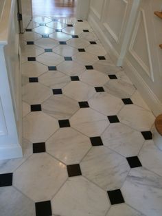 a hallway with black and white tiles on the floor