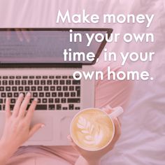 a woman holding a cup of coffee while using a laptop computer on top of a bed