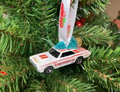 a white car ornament hanging from a christmas tree