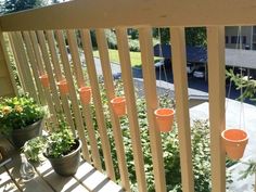 several hanging planters on the side of a porch