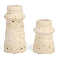 two white vases sitting next to each other on a white surface with no one around them