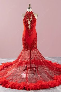 a red mermaid style dress with feathers on the bottom and back, in front of a mann