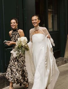 two brides walking down the street in their wedding gowns and dresses with lace on them