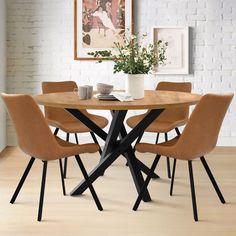 a table with four chairs around it in front of a brick wall and potted plant