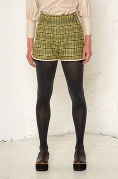 The sports luxe trend is given a smart update with these gorgeous check shorts. They’re made from roll-end soft wool blends that help cut down on fashion waste. The shorts have an elasticated waist for a comfortable fit and are finished with contrasting piping around the leg.The Dolly shorts are available in two colors: brown and green. The neutral tones make them easy to pair with other garments, and they can easily be dressed up with a silky blouse or long-sleeve jersey. Only 30 pieces of each color will be produced. Roll End Wool Blend (60% Wool / 40% Polyester) exclusive of trim Made in England Dry Clean Fashion Waste, Office Fits, Pants Model, Placement Print, Water Waste, Brown And Green, Silky Blouse, Organic Ring, Sports Luxe