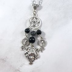 This Medusa pendant necklace is the perfect way to express your affinity for the Greek myths in subtle way. Pendant is made with four charms: Pentacle Medusa Head 2 snake charms 3 tourmaline beads and one labradorite bead also make up the pendant. Available in a variety of lengths. Chain is stainless steel, charms are zinc alloy and beads are natural gemstone. All materials are lead and nickel free. Comes in a jewelry box so it's ready to be given as a gift. Have a idea for a custom order? I'd l Symbolic Black Necklace With Moon Charm, Mystical Silver Gemstone Bead Necklace, Mystical Silver Necklace With Gemstone Beads, Spiritual Silver Charm Necklaces With Gemstone Beads, Spiritual Black Dangle Necklaces, Spiritual Black Necklaces With Charms, Spiritual Silver Onyx Beaded Necklaces, Medusa Necklace, Medusa Pendant