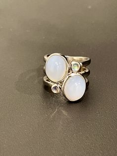 Sterling silver light purple moon stone ring bezel set with 2 oval cut moonstones and 2 round moonstones with a rhodium plating in a size 5. Moon Stone Ring, Purple Moon, Ring Bezel, Valley View, Dope Jewelry, Silver Lights, Purple Stones, Moonstone Ring, Moon Stone