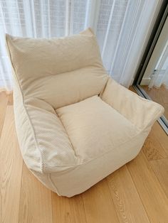 a white chair sitting on top of a hard wood floor next to a sliding glass door