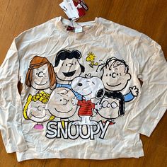 a white shirt with the words snoopy on it and three cartoon characters drawn on it