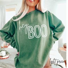 Hey Boo fall sweashirt printed on comfort colors. Perfect sweater for this fall or Halloween season. This sweatshirtis unsisex sizing. For an oversized look, please size up 1-2 sizes.   Luxurious comfort and style are what this unisex, garment-dyed sweatshirt is all about. It's made with 80% ring-spun cotton and 20% polyester and the fabric is 3-end garment-dyed, ring-spun, color-blast fleece with a 100% cotton face. Each sweatshirt comes with a relaxed fit, a rolled-forward shoulder, and a back Halloween Hoodies Cricut, Cricut Fall Sweatshirt Ideas, Fall Hoodie Ideas, Oversized Screen Print Sweater For Fall, Oversized Fall Sweater With Screen Print, Oversized Spooky Sweatshirt For Fall, Green Sweatshirt With Screen Print For Fall, Green Screen Print Sweatshirt For Fall, Spooky Cotton Sweatshirt For Fall