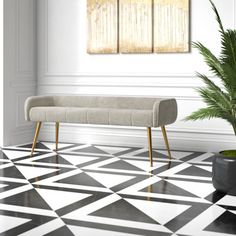 a white bench sitting next to a potted plant on top of a black and white floor