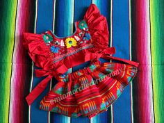 Serape birthday outfit, red mexican skirted bloomers, floral embroidered crop top, cotton ruffled sleeve top, taco twosday, red mexico dress This is a super cute Mexican outfit with a twist, the hand embroidered crop top it is beautiful, the ruffled sleeve, completely open on the sides and the tie bows, definitely gives the perfect touch to our original design. The outfit every girl will dream about Outfit includes: Floral embroidered crop top and skirted bloomers. Fits size 2T All our outfits are made with love and fits true to size. Care instructions: Wash by hand with cold water and hang to dry. * Visit the shop * https://www.etsy.com/shop/Miamorcitocorazon * Follow us on instagram * @miamorcitocorazonmx ------------------------------------------------------ I don't accept returns, exch Red Floral Embroidered Summer Sets, Red Sets For Summer Festival, Spring Red Ruffled Sets, Embroidered Red Summer Sets, Traditional Red Summer Sets, Red Cotton Sets For Festival, Traditional Red Sets For Summer, Traditional Red Set For Summer, Red Dress For Cinco De Mayo Fiesta