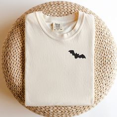 Add a touch of eerie elegance to your Halloween wardrobe with our exquisite Embroidered Bat Halloween T-Shirt. Crafted with attention to detail and a hint of spookiness, this shirt is the perfect blend of style and Halloween spirit. Whether you're heading to a costume party or just want to show off your festive side, this t-shirt is a must-have addition to your collection. Product Details: Design: A stunningly detailed bat embroidery that captures the mystique of the night. The intricate stitching brings out the bat's intricate wings and features, creating a captivating visual. Material: Premium quality cotton ensures comfort and durability, making this t-shirt perfect for extended wear throughout the Halloween season and beyond. Fit: A relaxed and comfortable fit suitable for all body typ Halloween Embroidered Cotton Tops, Halloween Cotton Embroidered Tops, Embroidered Cotton Tops For Halloween, Halloween Embroidered Long Sleeve T-shirt, Halloween Long Sleeve Embroidered T-shirt, Embroidered Long Sleeve T-shirt For Halloween, Halloween Embroidered Crew Neck T-shirt, Bat Top, Bat Embroidery