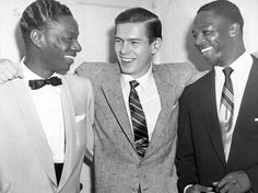 three men in suits are laughing together