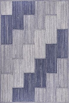 a blue and white area rug with squares on the bottom, in different shades of grey