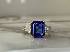 14kt white gold ring set with a genuine 4.46ct (10.6x8.7mm) tanzanite and accented with .83ct total weight of diamonds (.63cttw trapezoids and .20cttw round). Weighs 3.9dwt and is currently a size 7.75 but can be resized! Tanzanite Engagement Ring, Tanzanite Diamond Ring, Wedding Goals, White Gold Rings, Rings Statement, Ring Sets, Sapphire Ring, Statement Rings, Diamond Ring