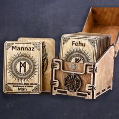 three wooden playing cards in a box with the letter m on each side and an image of a man