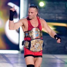 a man in a red wrestling outfit holding his fist up