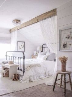 a bedroom with white walls and an iron bed frame in the corner, along with a rug on the floor