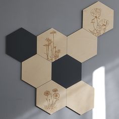 four wooden hexagons with flowers on them are hanging on the wall next to a window