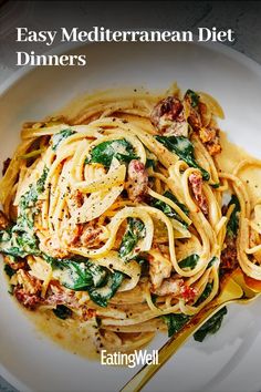 a white plate topped with pasta and spinach