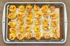 a baking pan filled with mini pizzas covered in cheese and ham