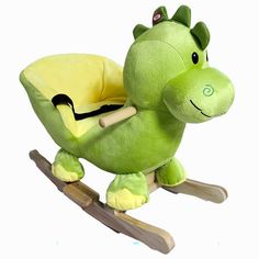 a green stuffed animal sitting on top of a wooden rocking toy