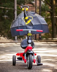 a kid's tricycle with an umbrella attached to the front wheel and seat