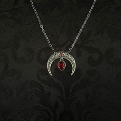 "This simple pendant features a richly detailed antiqued silver tone crescent, adorned with dazzling dark ruby red glass crystals. Pendant is 1 1/8\" wide and 1\" tall.  Necklace length is adjustable with soldered stainless steel cable chain, lobster clasp and extender. If you would like a different length, please send us a message. Matching headpiece, pendant and earrings are listed separately in our store. If you don't see items with a color you want, feel free to ask about availability." Red Moon Necklace, Silver Vampire Style Metal Jewelry, Medieval Silver Jewelry For Halloween, Medieval Jewelry For Halloween Gift, Gothic Red Ruby Jewelry, Red Gothic Necklace Nickel Free, Gothic Red Nickel-free Necklace, Red Gothic Metal Necklace, Red Gothic Nickel-free Necklace